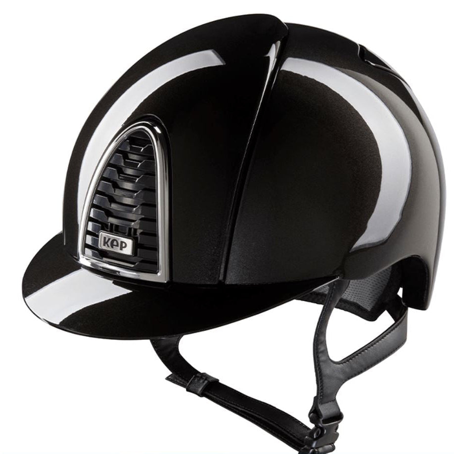 A glossy black equestrian riding helmet with a chin strap, featuring a silver-trimmed vented side panel with a visible KEP logo