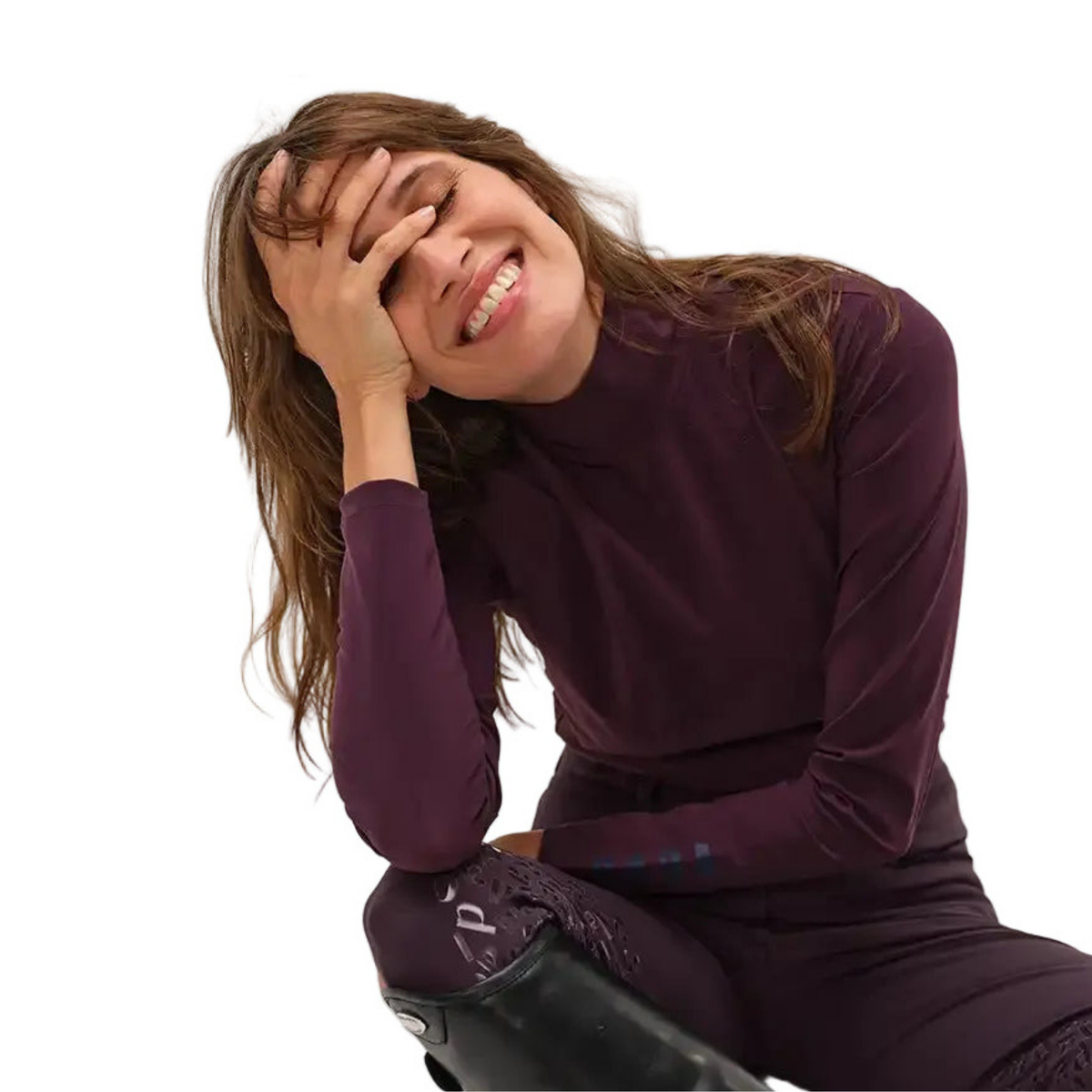 A woman with long brown hair wearing a matching dark plum purple long-sleeve mock neck top and leggings set, sitting against a solid white background.