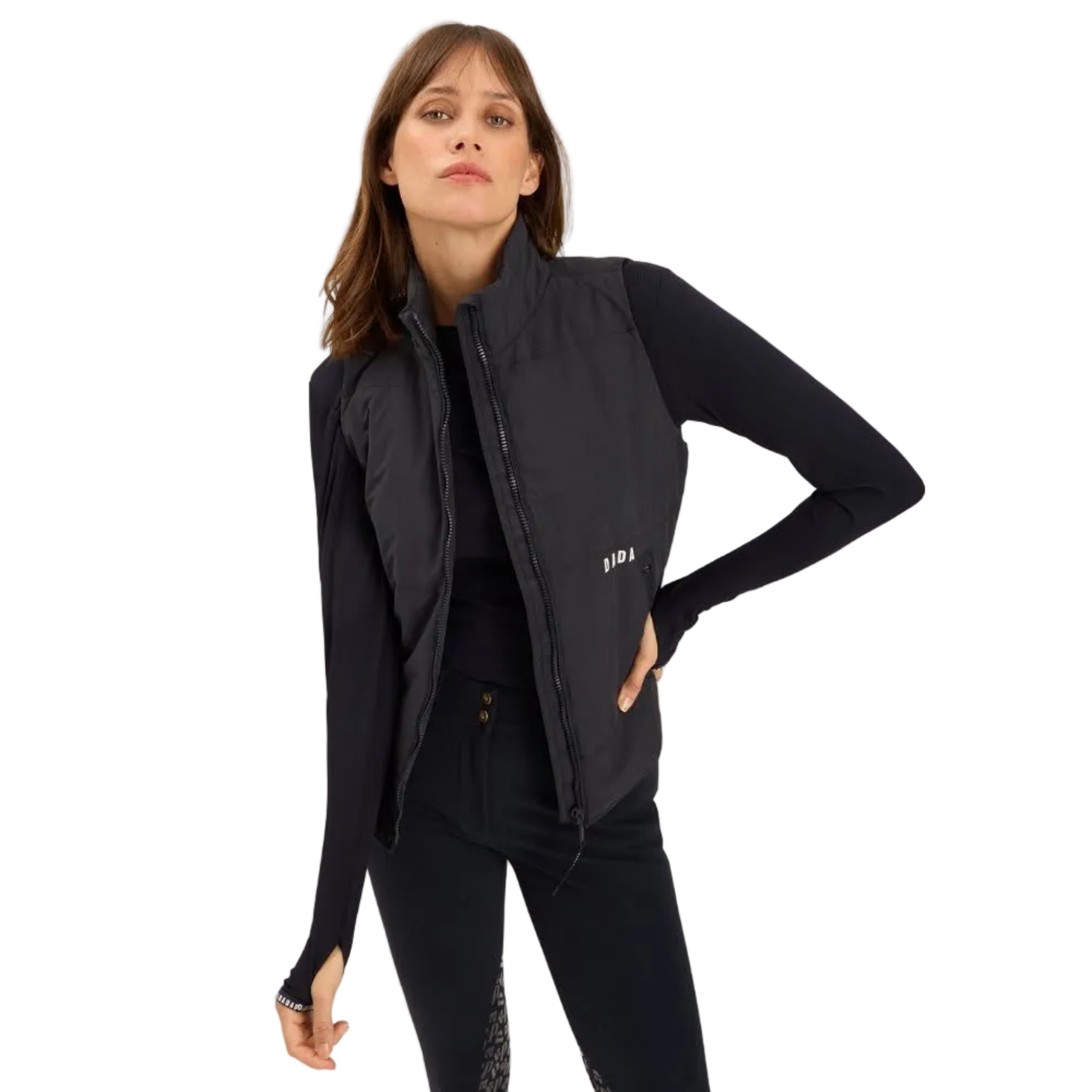 A woman modeling a black sleeveless zip-front puffer vest over a black long-sleeve top and black pants, photographed against a plain white studio background.