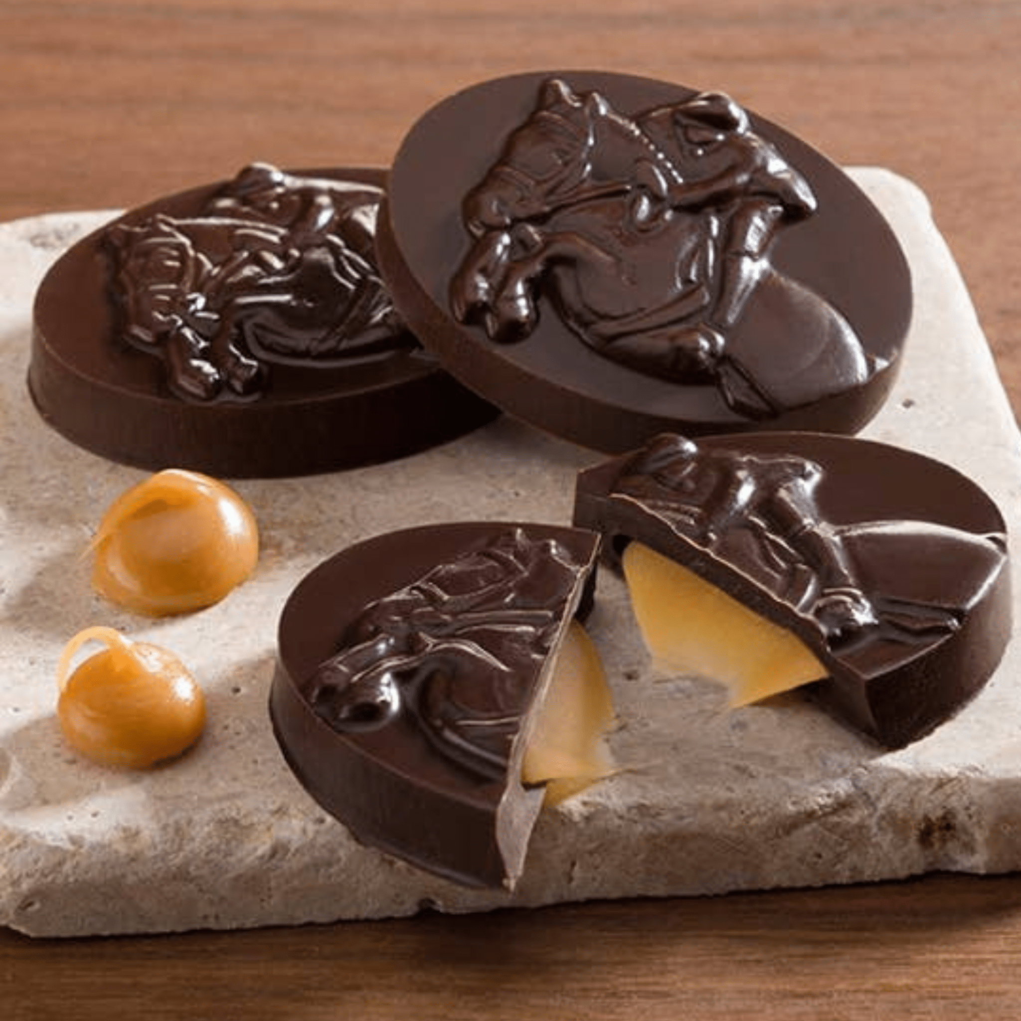 Chocolate candies with horse designs on a stone surface