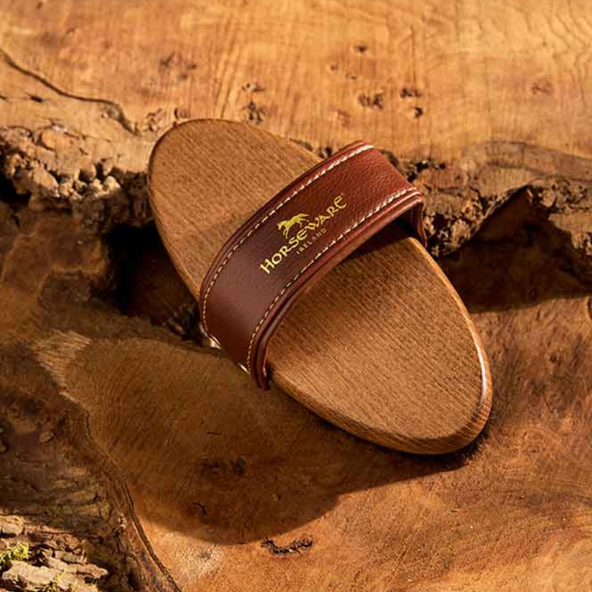 Brown sandal with a strap on a wooden surface