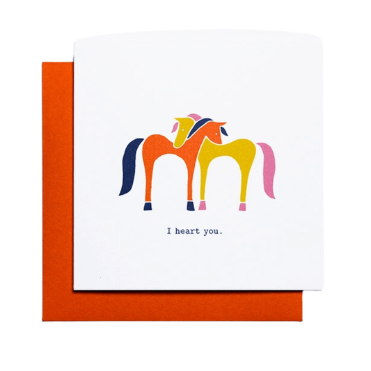Card with text, "I heart you." Image: orange horse with blue mane and tail hugging yellow horse with pink mane and tail.