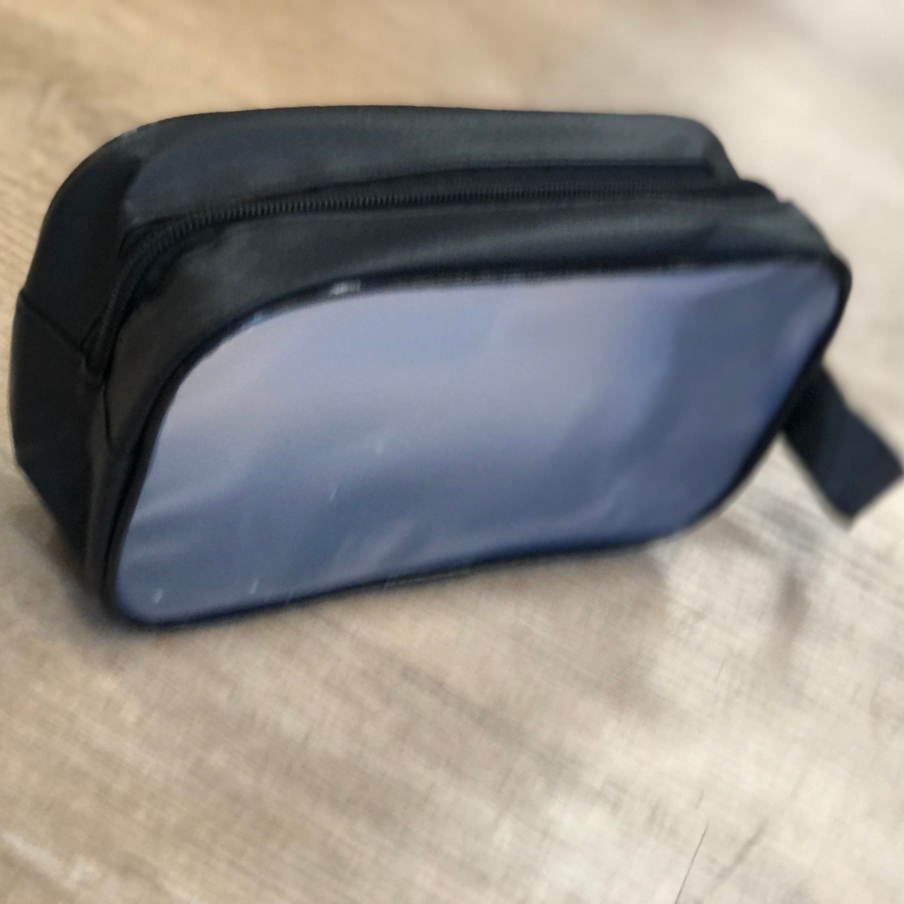 Black toiletry bag on a wooden surface