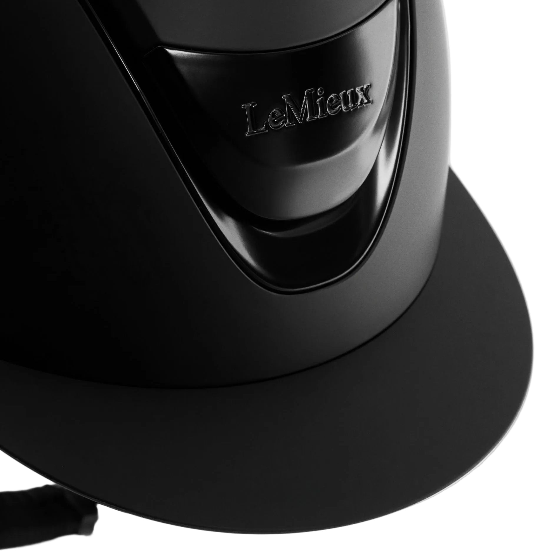 Black equestrian helmet with 'LeMieux' branding on a light gray background