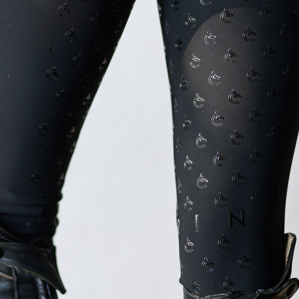 Black textured leggings with a pattern on a white background