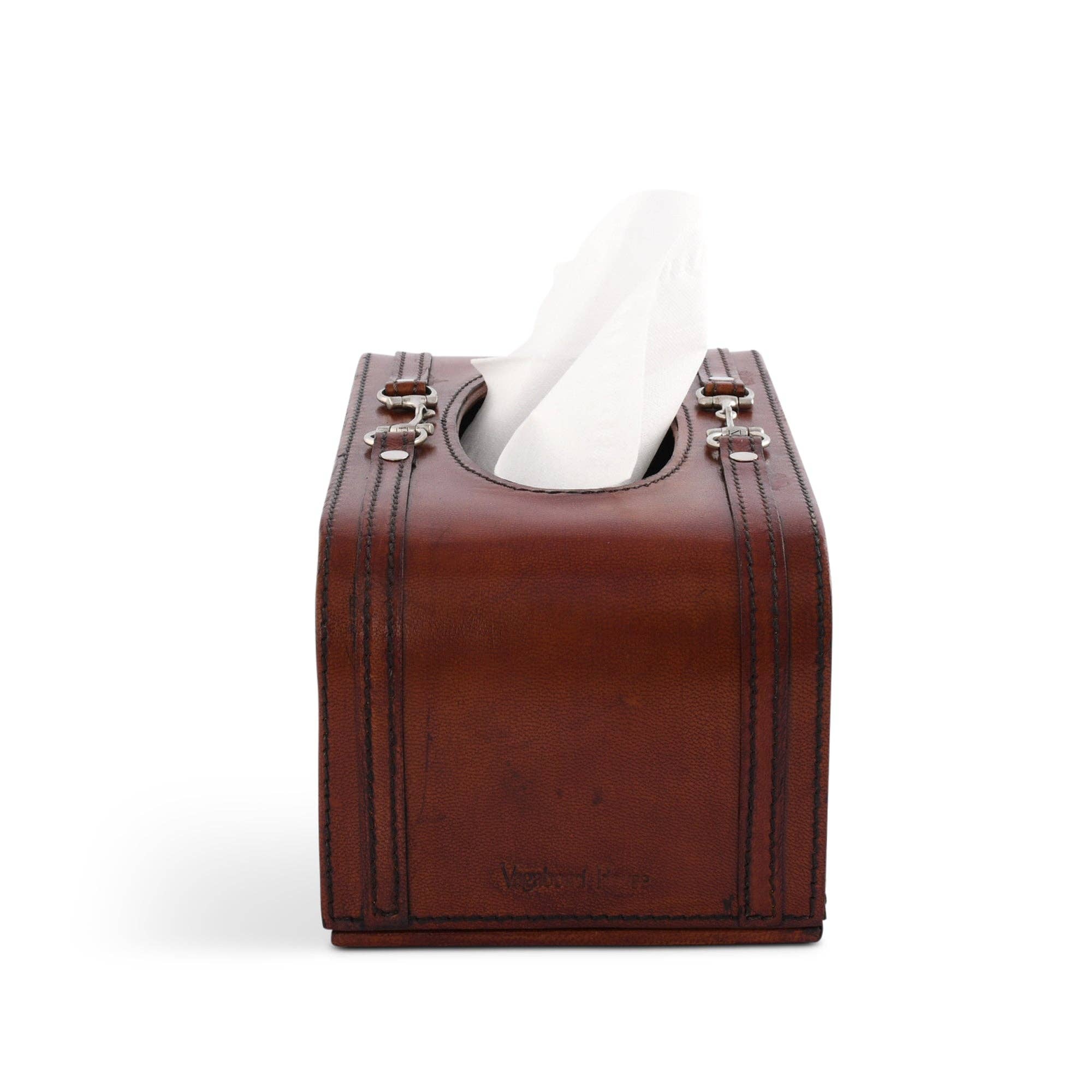 Brown leather tissue box cover with a white tissue peeking out on a white background