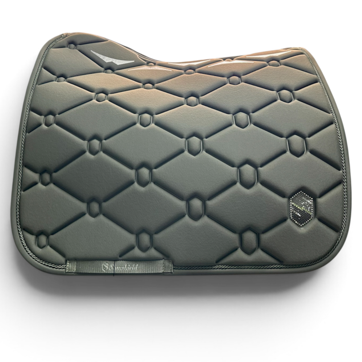 A dark gray quilted equestrian saddle pad with a diamond pattern, featuring a small hexagonal logo patch on the lower right and a brand tag on the lower left, set against a plain white background.
