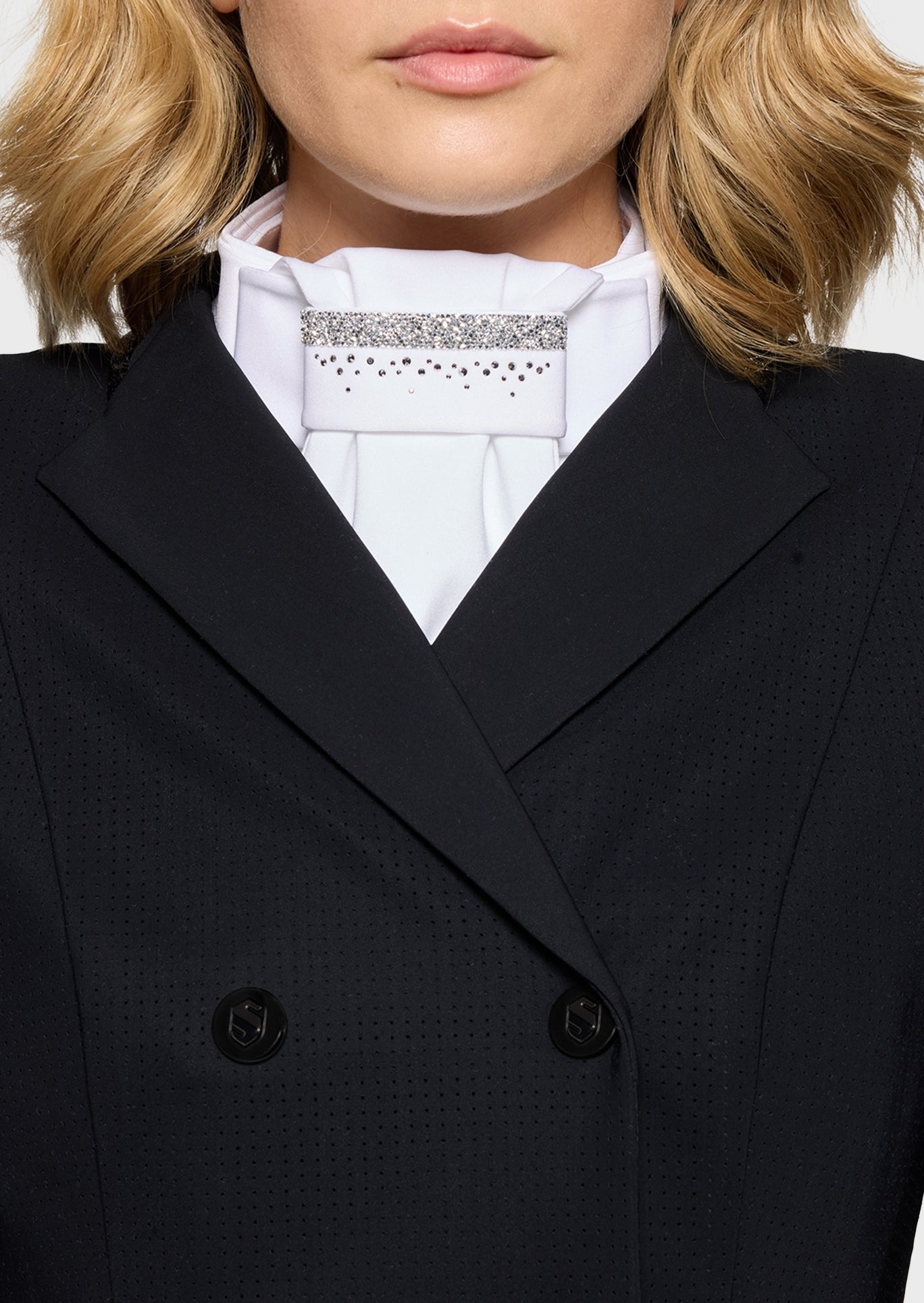 Close-up of a person wearing a black coat over a white shirt with lace details.