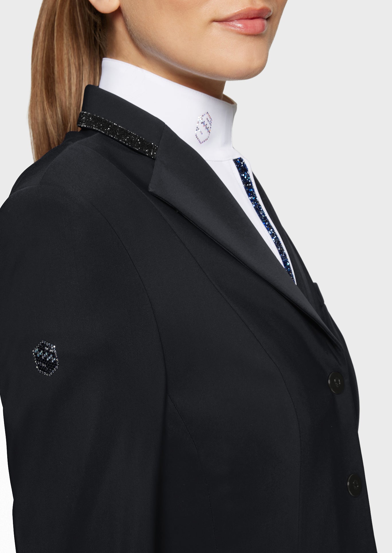 Black blazer with decorative buttons on a plain background