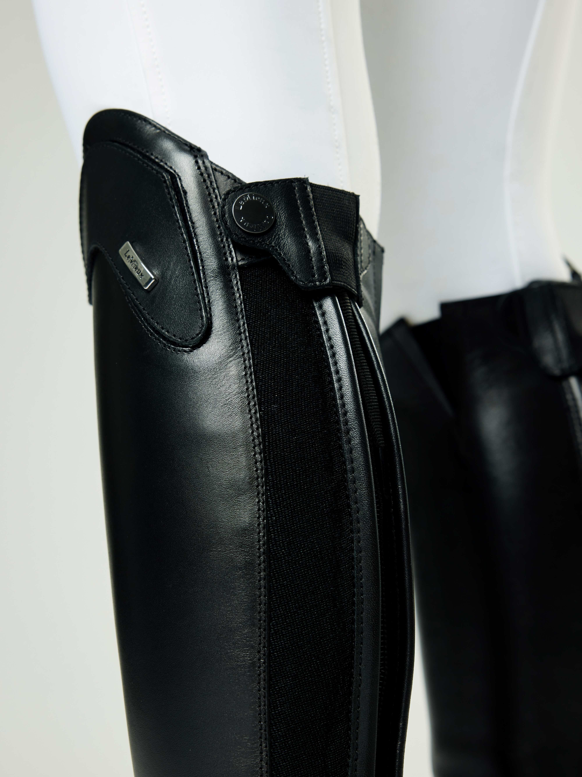 Close-up of black equestrian leg guards on a white background