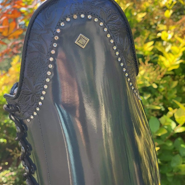 DETAIL VIEW OF NAVY GRETA AND CRYSTAL ACCENTS ON NAVY BRUSHED LEATHER DENIRO BOTTICELLI DRESSAGE BOOT WITH FRONT POLO LACES
