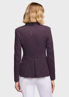A woman viewed from the back wearing a dark plum purple structured blazer with a peplum waist and white pants, set against a solid light gray background.