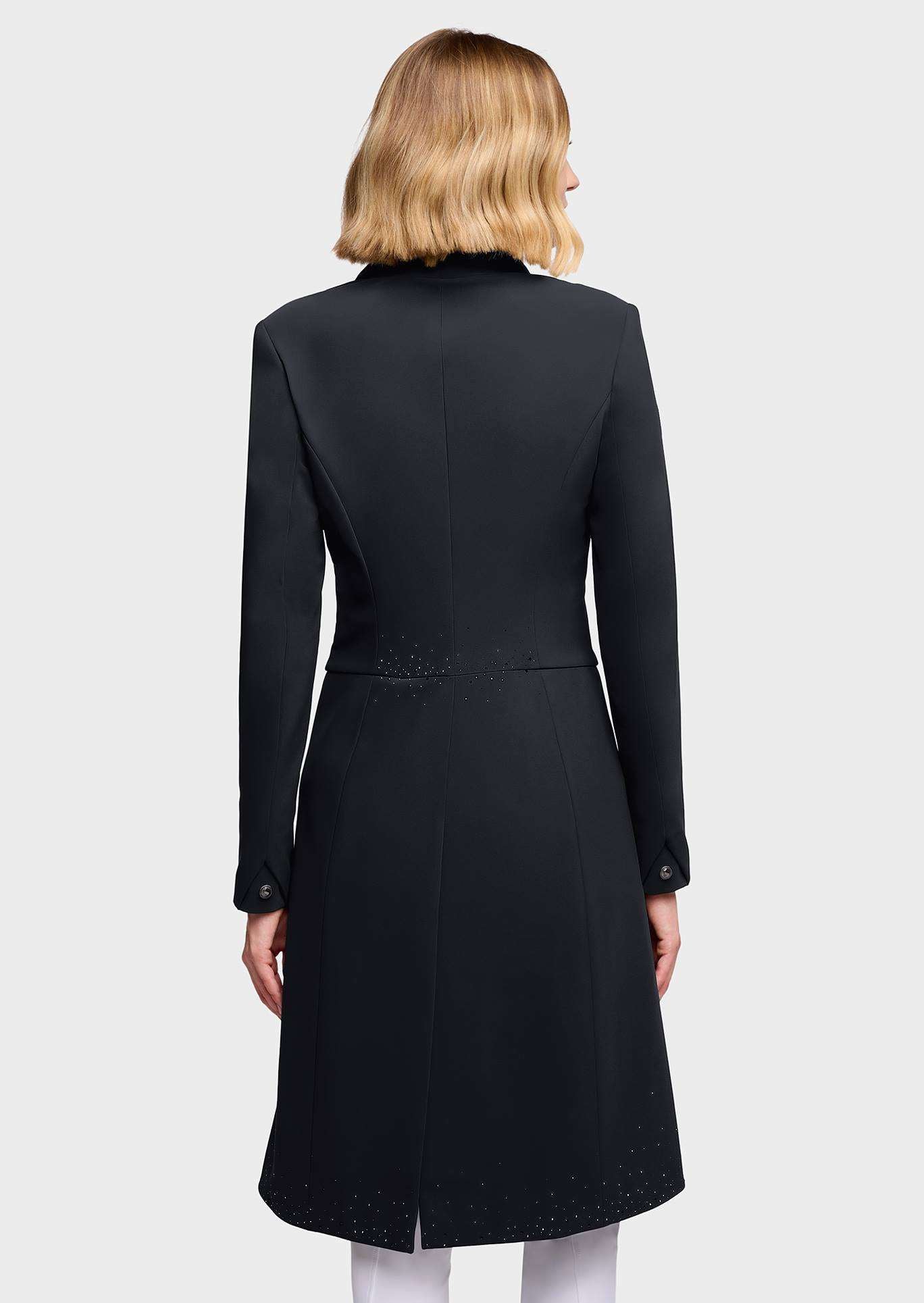 A woman shown from the back wearing a black longline coat with structured shoulders, long sleeves, and subtle embroidered detailing near the waist and hem, against a light gray studio background.