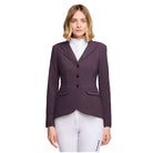 A woman modeling a dark plum purple equestrian blazer with three-quarter lapels, black buttons, and subtle embroidered detailing on the chest, paired with white riding breeches and a white collar shirt, against a light gray studio background.