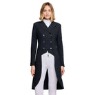 A woman modeling a black double-breasted equestrian style coat with silver buttons, worn over a white mock neck top and white breeches, against a light gray studio background.