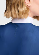 Close-up back view of a person wearing a royal blue satin-like top or dress with a contrasting white high collar, showing a small vertical stitched detail on the back.