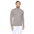 A man wearing a light gray mock neck knit sweater with a small embroidered logo on the chest, paired with white pants, against a light gray background.