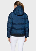 A woman viewed from the back wearing a navy blue puffer jacket with a small star pattern and a black ribbed hem, paired with white leggings, against a plain white background.