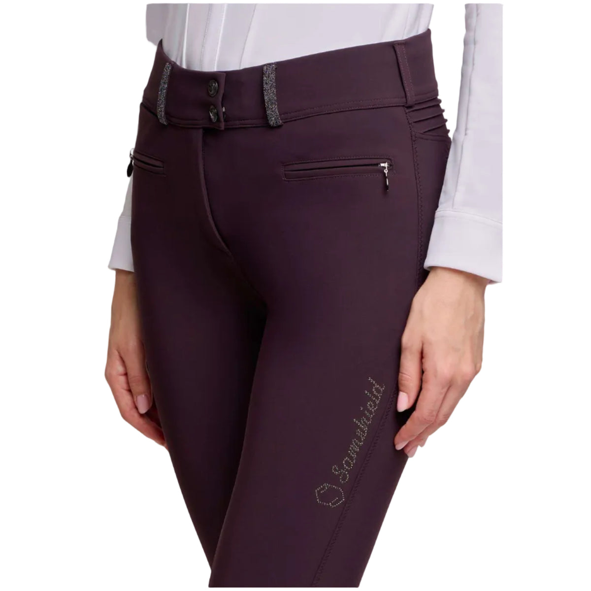 A close-up of a model wearing dark plum equestrian riding breeches with a decorative waistband, zippered side pockets, and a silver embroidered 'Scenicfield' logo on the left thigh.