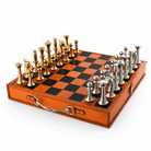 A portable chess set in a wooden case, featuring a checkered board with orange and black squares, gold-toned chess pieces on one side, and silver-toned chess pieces on the other, shown on a white background.