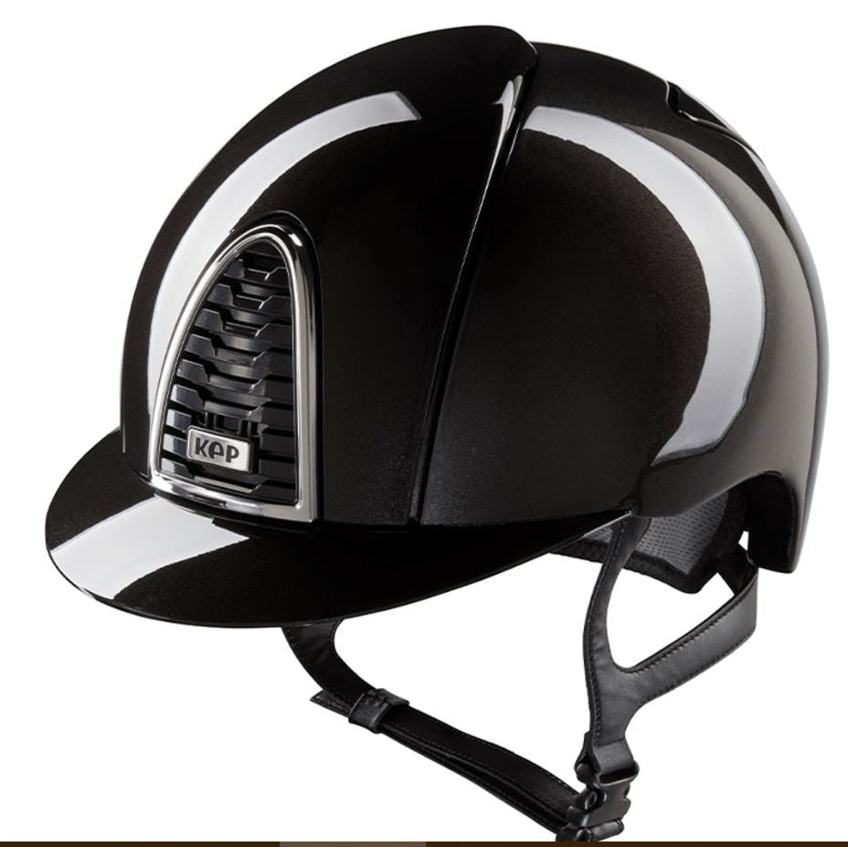A glossy black equestrian riding helmet with a chin strap, featuring a silver-trimmed vented side panel with a visible KEP logo