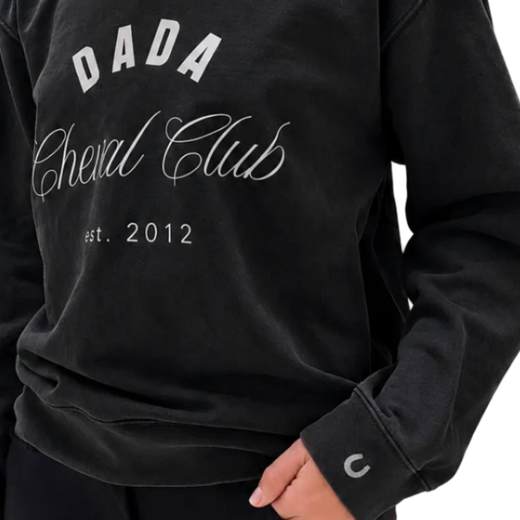 A close-up of a person wearing a black sweatshirt with white printed text reading 'DADA Cheval Club est. 2012' on the front.