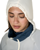 Woman wearing a white hooded jacket against a white background