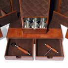 Brown leather caddy with silver cups and wooden corkscrews on a white background