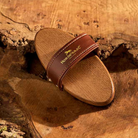 Brown sandal with a strap on a wooden surface