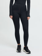 Person wearing black leggings and black shoes on a white background