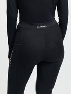 Person wearing black riding pants with 'LeMieux' branding on a white background