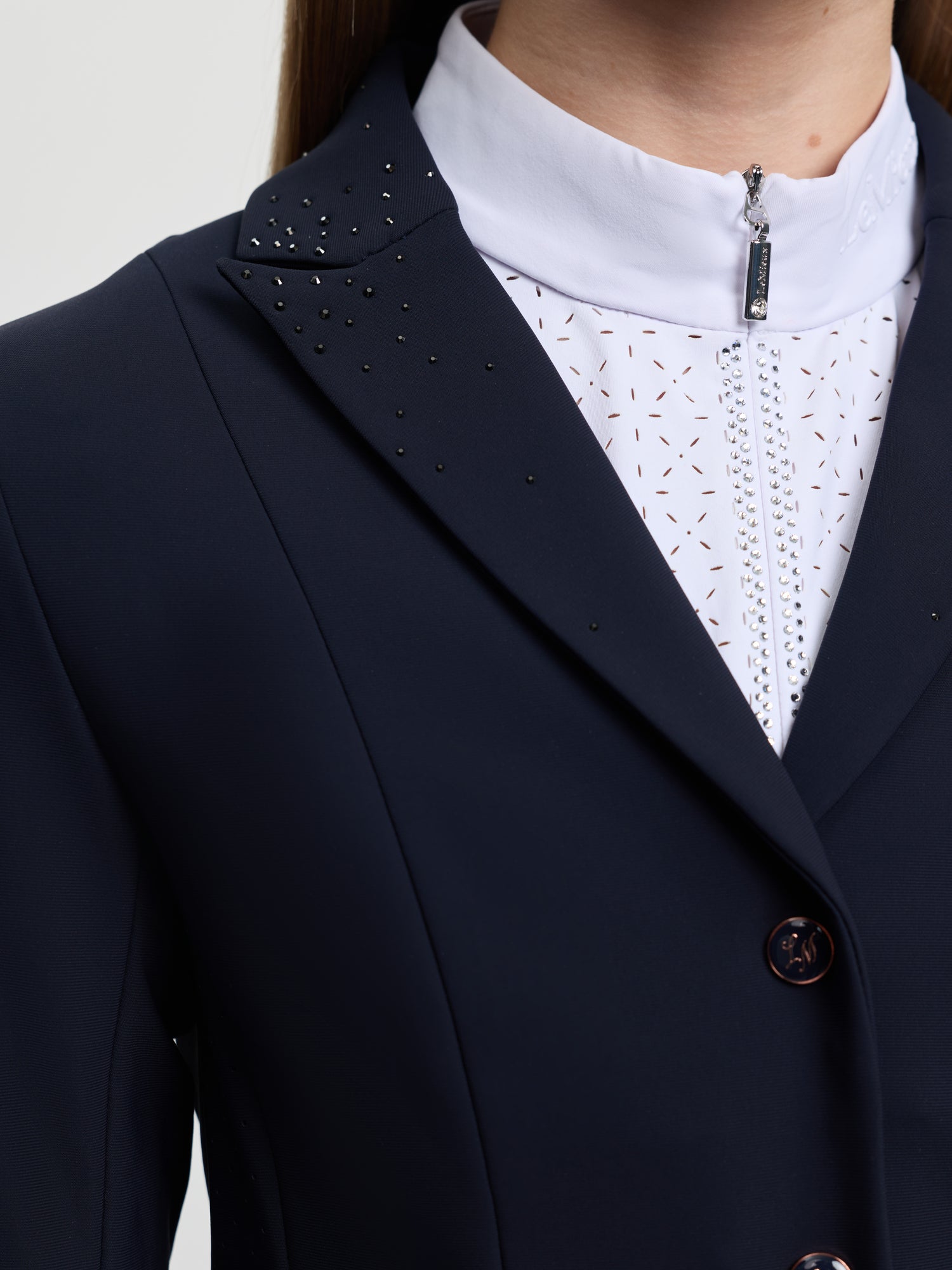 Navy blazer with decorative elements and a white lace shirt underneath.