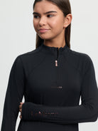 Woman wearing a black long-sleeve top with 'LeMieux' branding on a light gray background