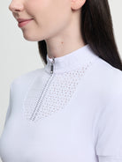 Close-up of a person wearing a light blue blouse with intricate detailing on a plain background
