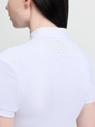 White polo shirt worn by a person on a light gray background
