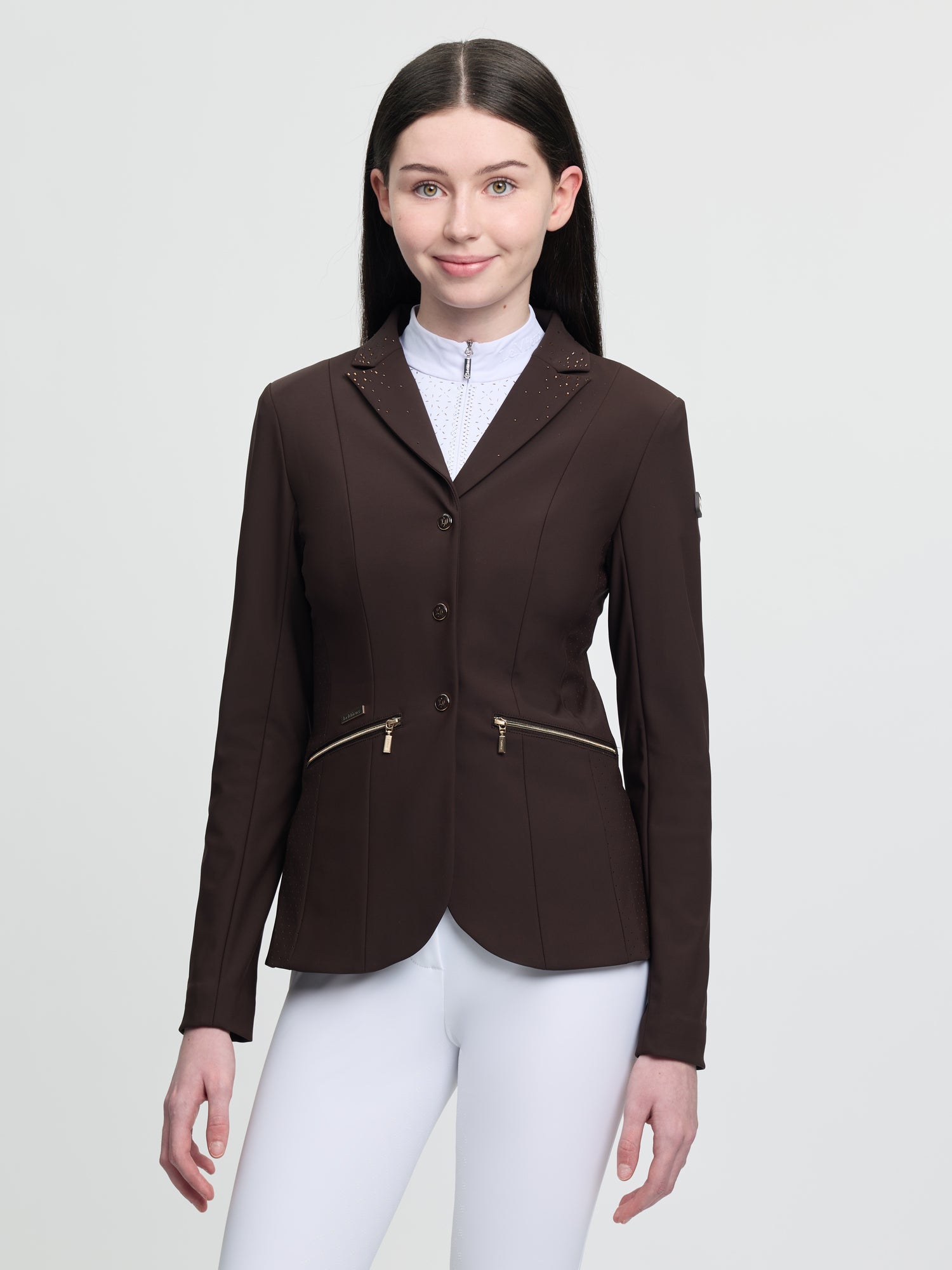 Woman wearing a brown equestrian jacket on a white background