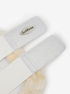 Gray grooming brush with a visible brand logo on a white background