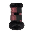 A winter boot or shoe bootie featuring black faux fur trim and a metallic rose gold glitter strap with a black elastic band and hook-and-loop closure, shown against a plain light gray background.