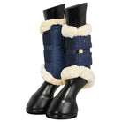 A pair of navy blue and navy glitter equestrian leg boots with cream shearling lining, shown on black horse boots against a light gray background.