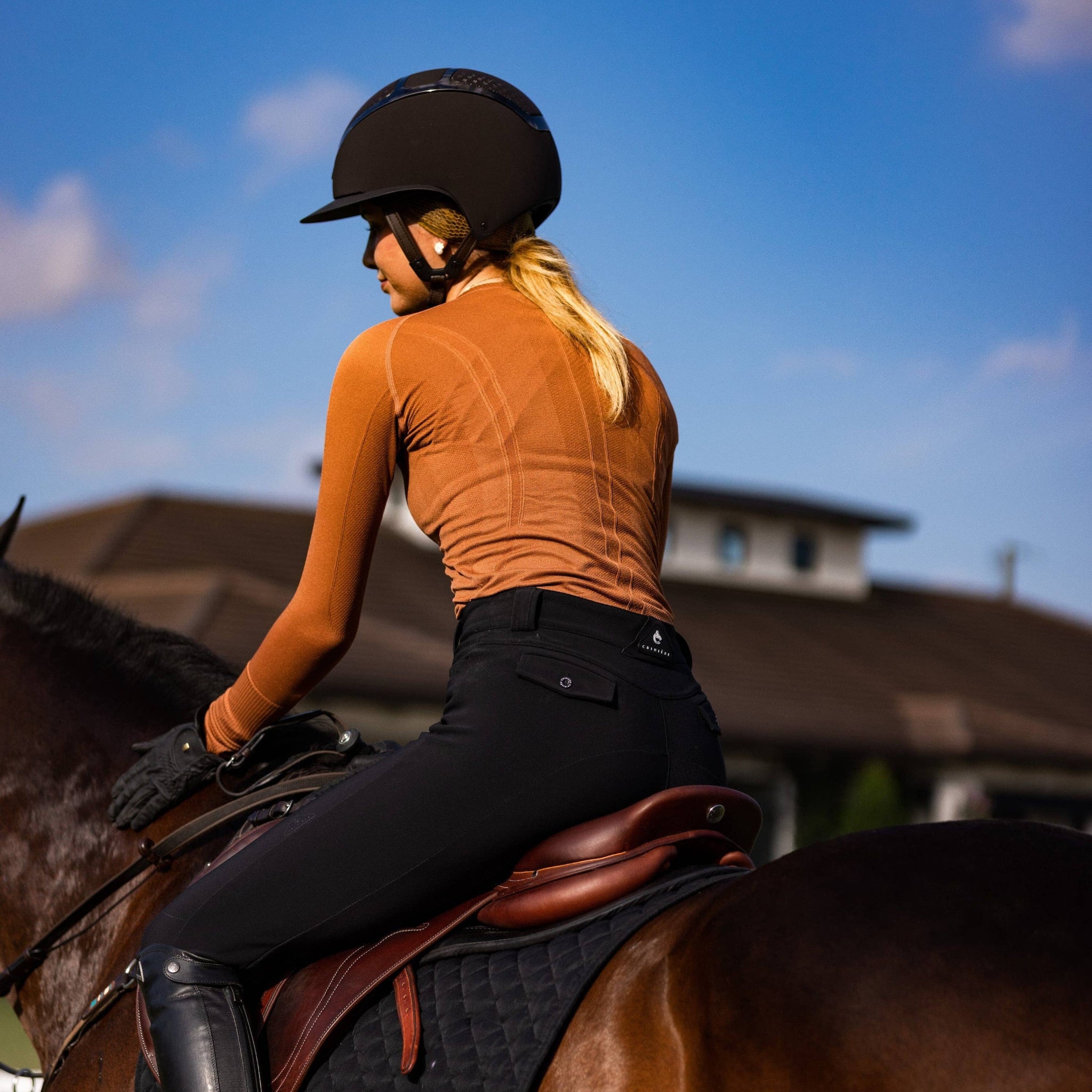 Person riding a horse with a clear blue sky in the background