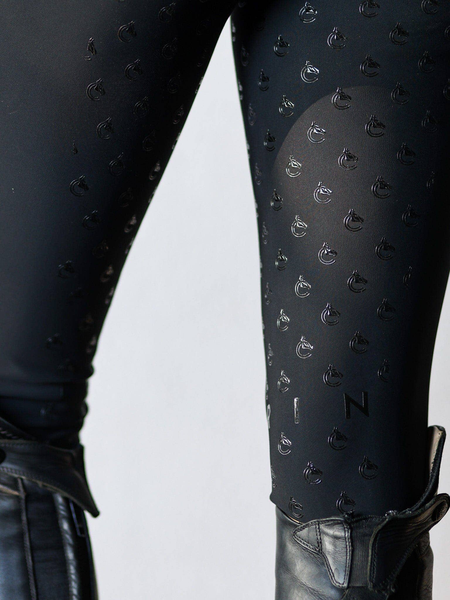 Black textured leggings with a pattern on a white background
