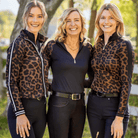 Three women wearing leopard print and black outfits standing outdoors.
