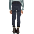 Rear view of a person wearing dark navy equestrian riding breeches with a subtle leopard pattern and a black waistband, paired with a sage green long-sleeve shirt and brown ankle boots, on a white background.