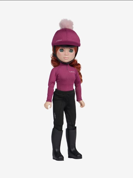 A doll with long red hair wearing a magenta riding helmet with a pom-pom, a matching magenta long-sleeve top, black riding pants, and black riding boots, shown against a plain light gray background.