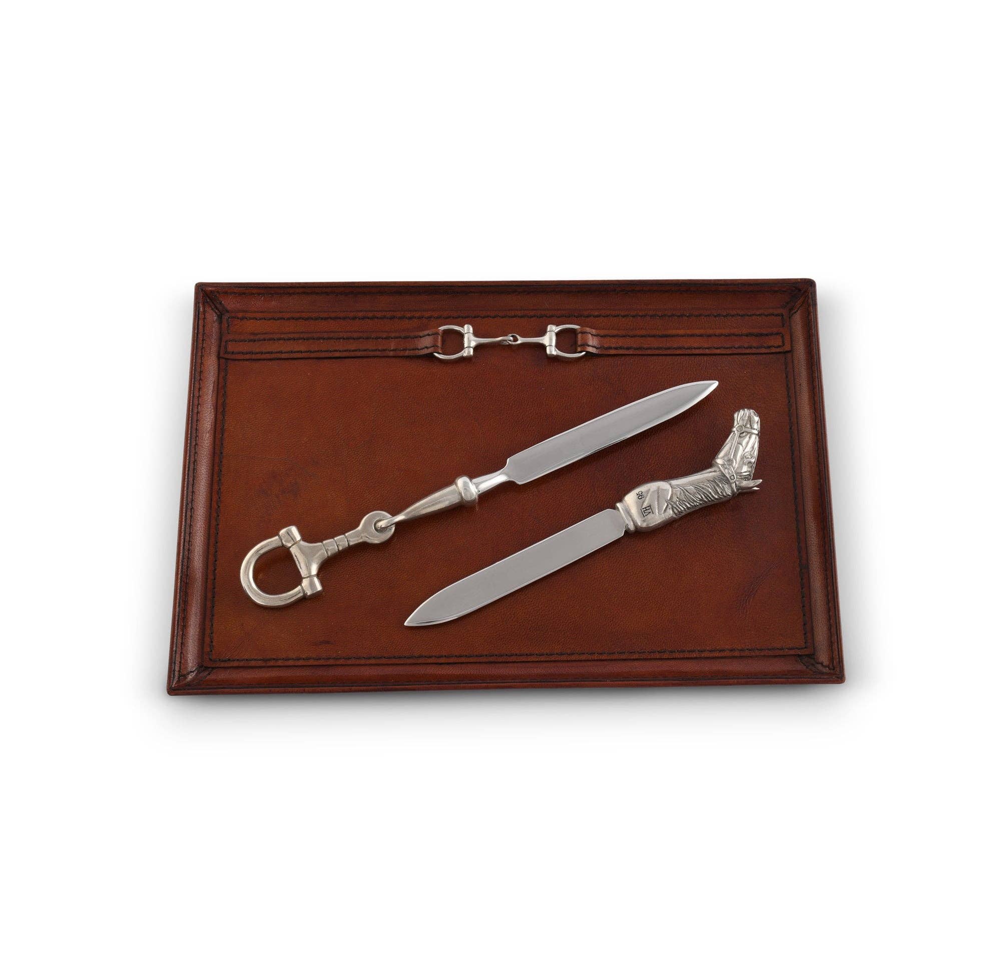 Two silver letter openers on a wooden tray with a white background