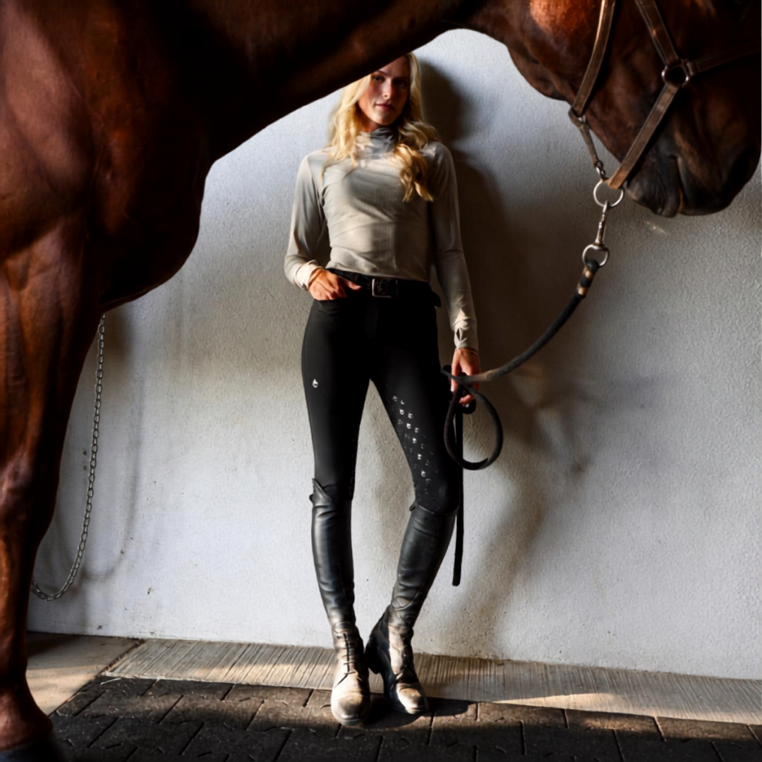 woman standing behind horse with black breeches on