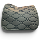 A dark gray quilted equestrian saddle pad with a diamond pattern, featuring a small hexagonal logo patch on the lower right and a brand tag on the lower left, set against a plain white background.