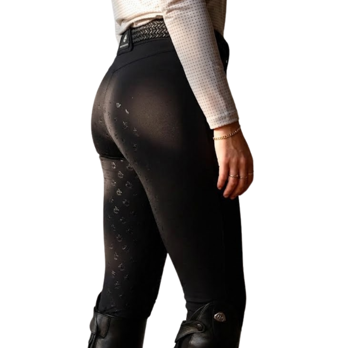 Black equestrian riding tights with a subtle repeating horse bit pattern on the lower legs, shown on a model from a rear three-quarter view against a white background.