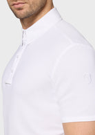 Close-up of a white polo shirt with brand logo on a plain background