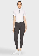 Woman wearing a white top and gray riding pants on a white background